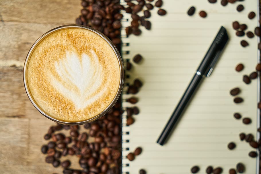 coffee cup filled with cappuccino and black gel pen on white notebook, HD wallpaper