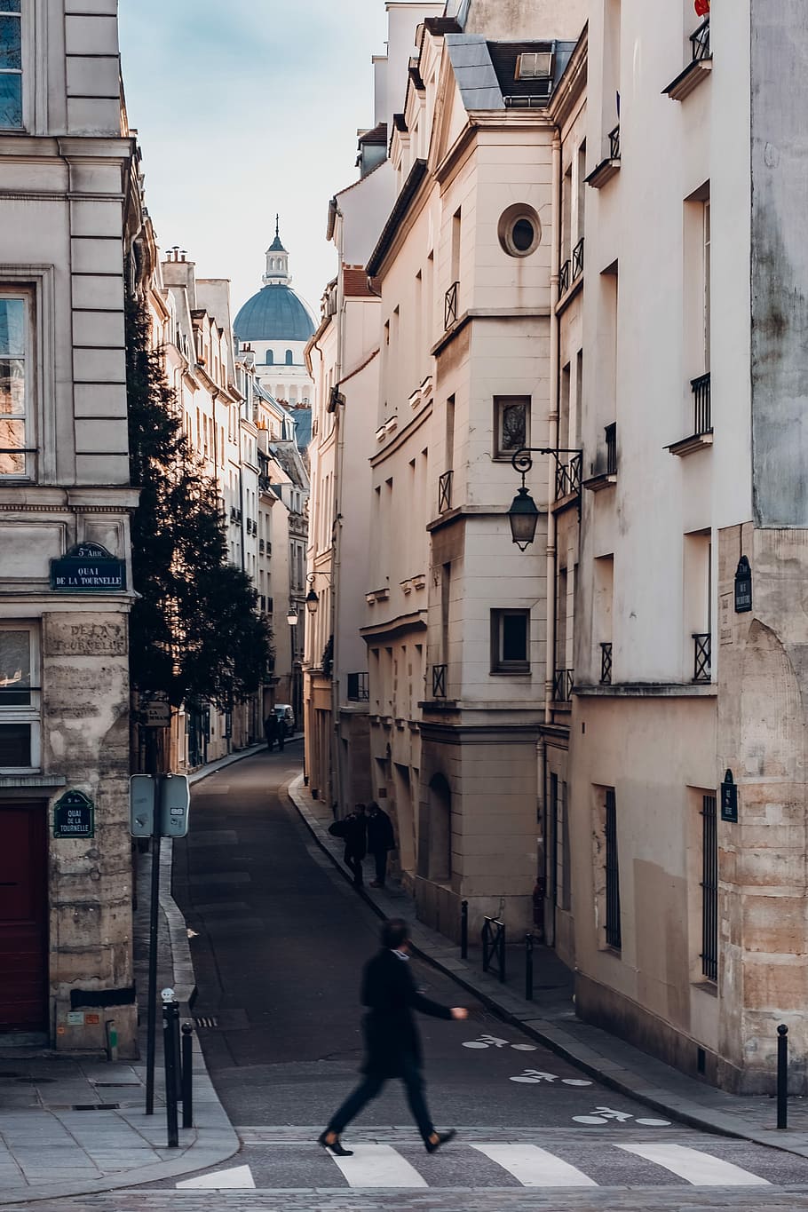 photography of person walking on sideway looking at leftside with buildings, person walking in middle of buildings HD wallpaper