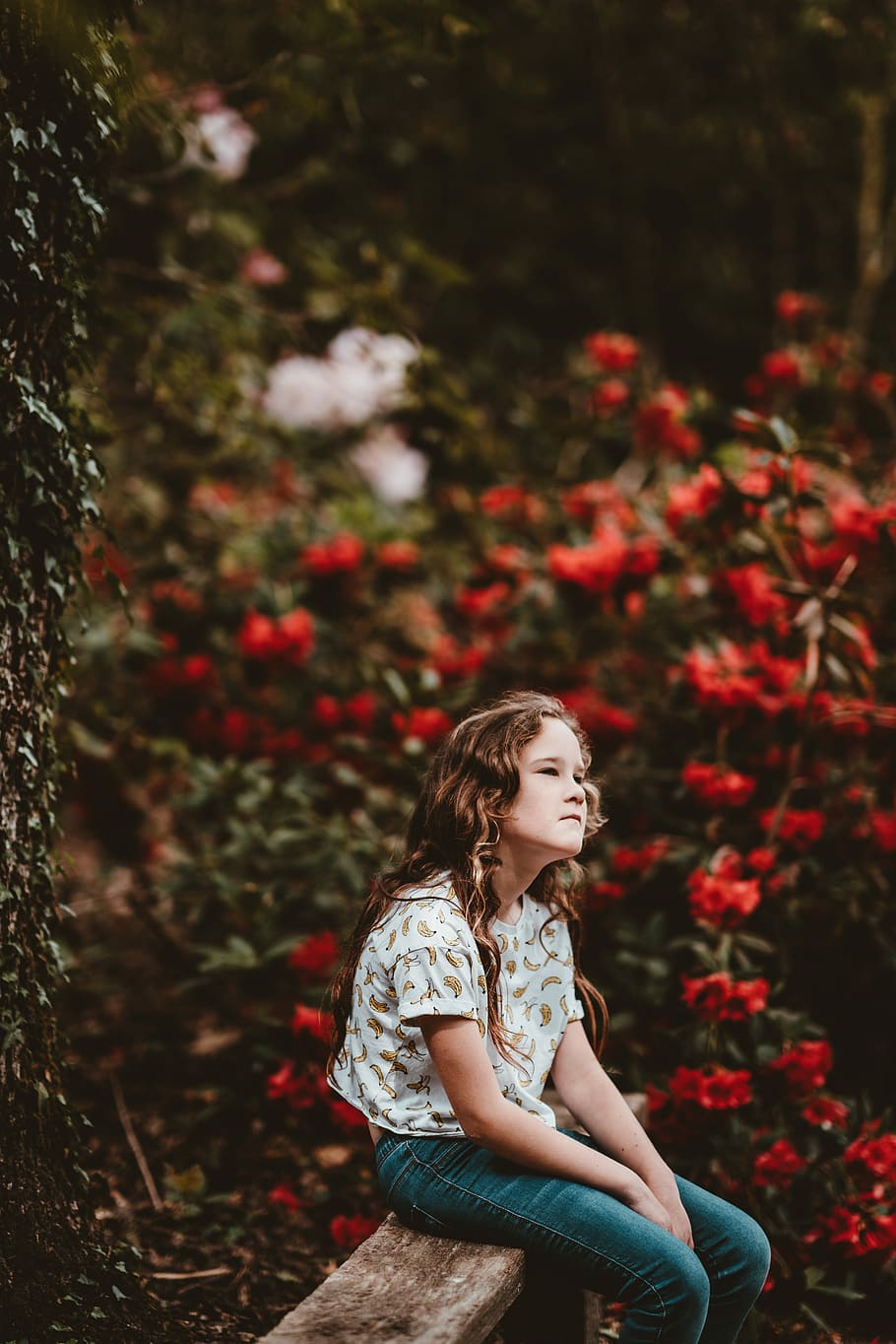 Premium Photo | Brownhaired girl poses near pinkish flowers on bush