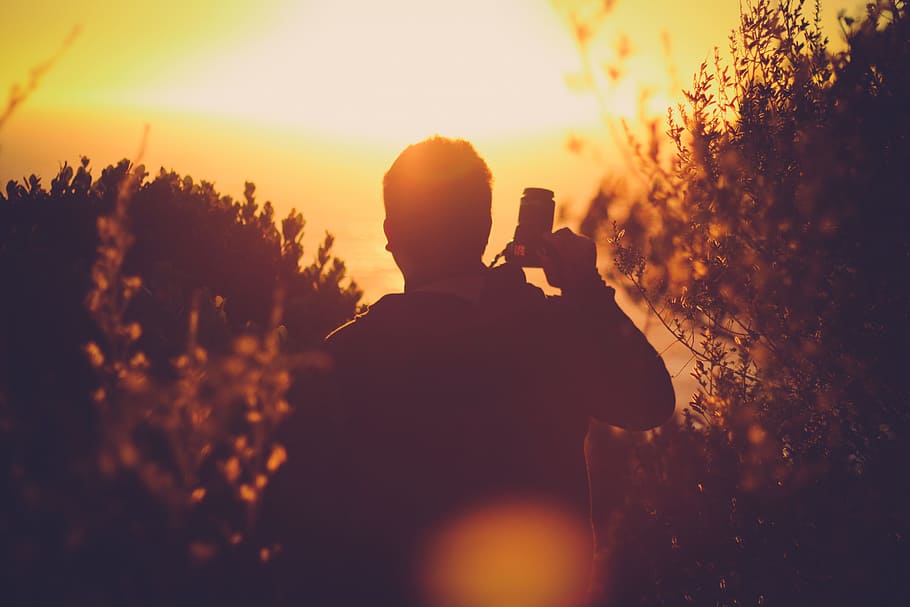 man standing holding DSLR camera in right hand, Sunset, Summer HD wallpaper