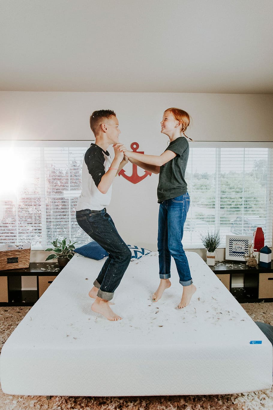 boy and girl jumping on white bed mattress inside room, boy and girl jumping on bed inside room HD wallpaper
