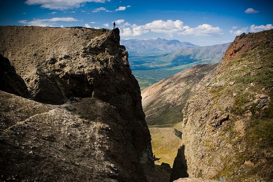 person standing near cliff, landscape, scenic, mountains, outdoors