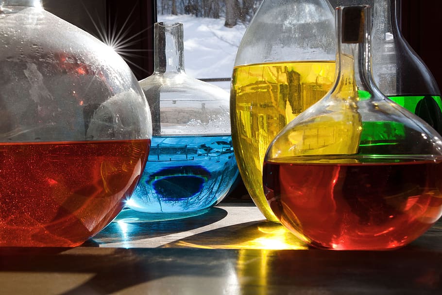 decanters filled with liquid, green, yellow, blue, red, colored