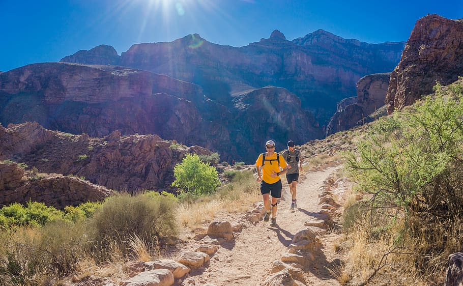 two person running through the field, two man running on brown mountains HD wallpaper