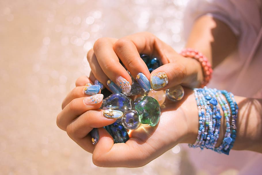 person holding green and purple gel beads during daytime, human Hand HD wallpaper