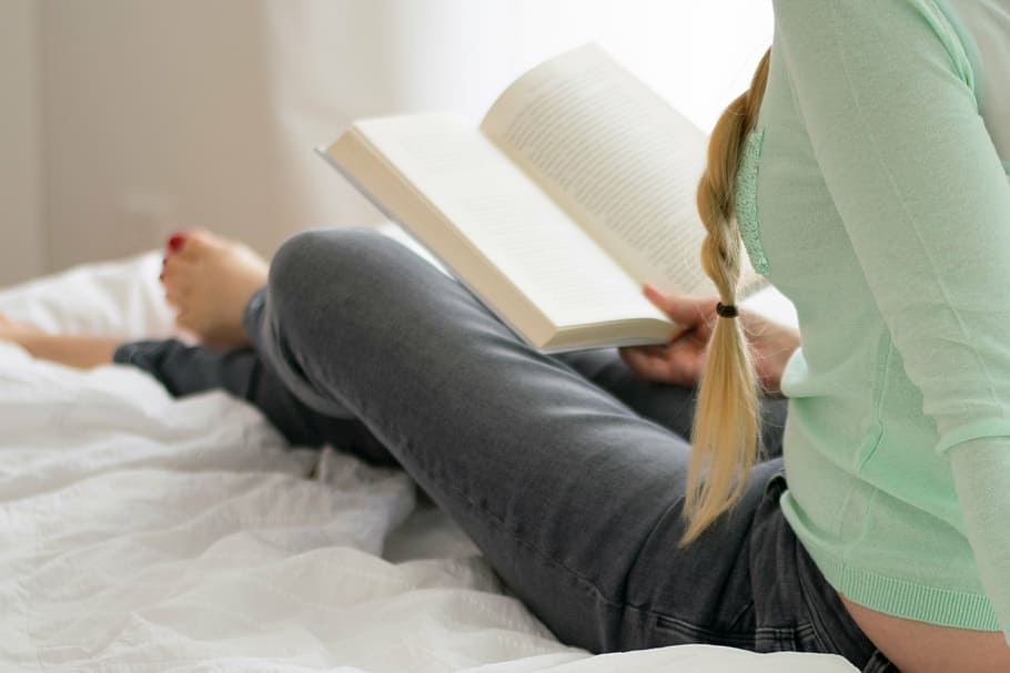 woman sitting on bed while reading book, bedroom, pillow, comforter HD wallpaper