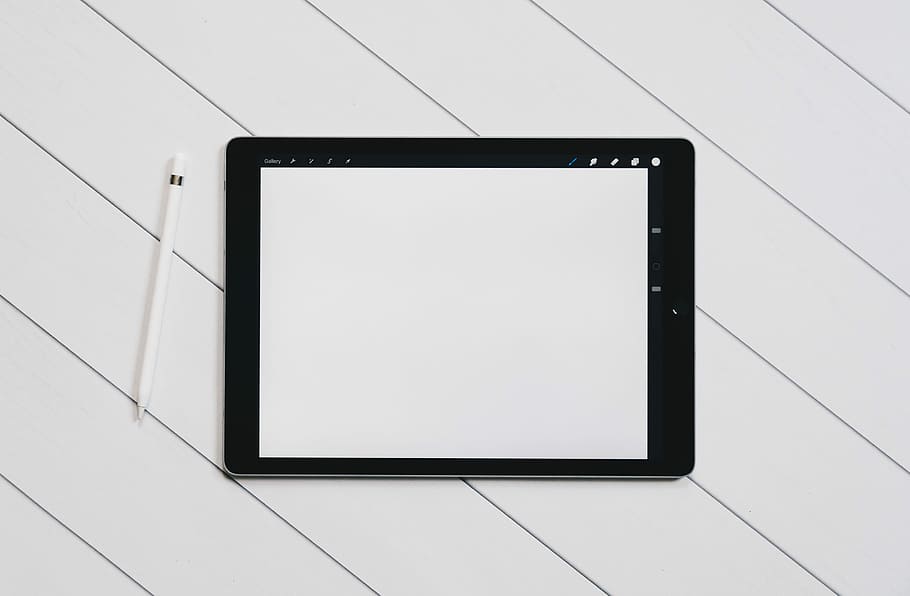 black drawing tab on white table, flat lay photography of black iPad