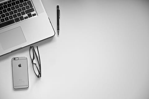space gray iPhone 6 with clear rear case near eyeglasses and MacBook Pro HD wallpaper