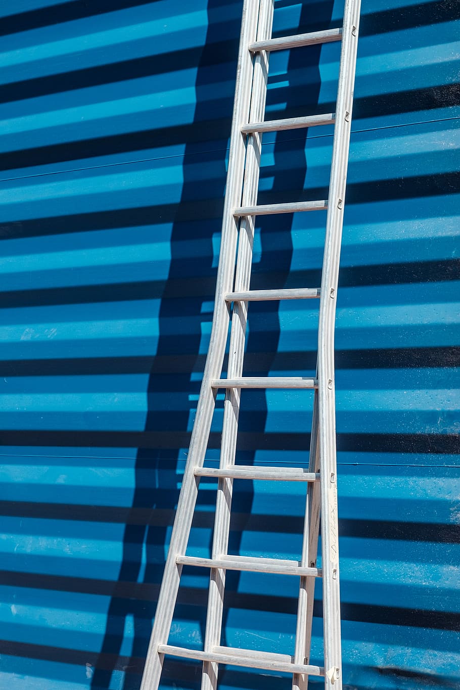 gray metal ladder leaning on blue corrugated sheet, gray step ladder learning on blue roll-top door HD wallpaper