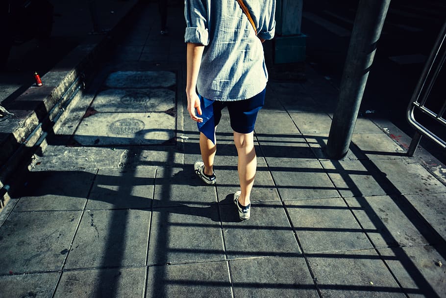 person standing on gray pavement during daytime, person walking on street HD wallpaper