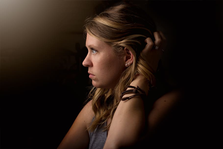 shallow focus photography of person holding her hair, low light photography of woman holding her hair HD wallpaper