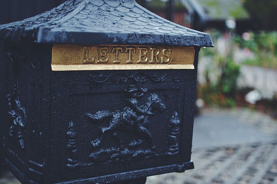 black man riding horse emboss-printed mail box, close-up photography of black and brass-colored letters box