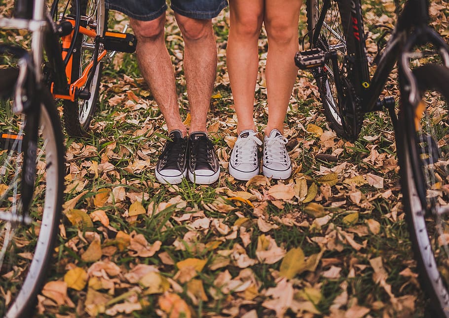 two person standing between mountain bikes, two person standing beside each other