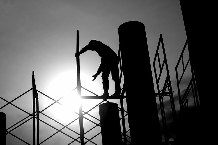 silhouette photography of man standing on scaffold, construction