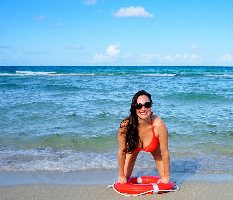 woman squatting on seashore, person, beach, young, happy, life preserver