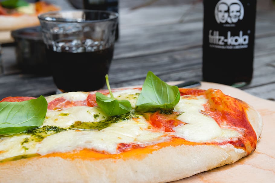 Pizza Top With Green Leafy Vegetable Near Glass of Black Liquid HD wallpaper