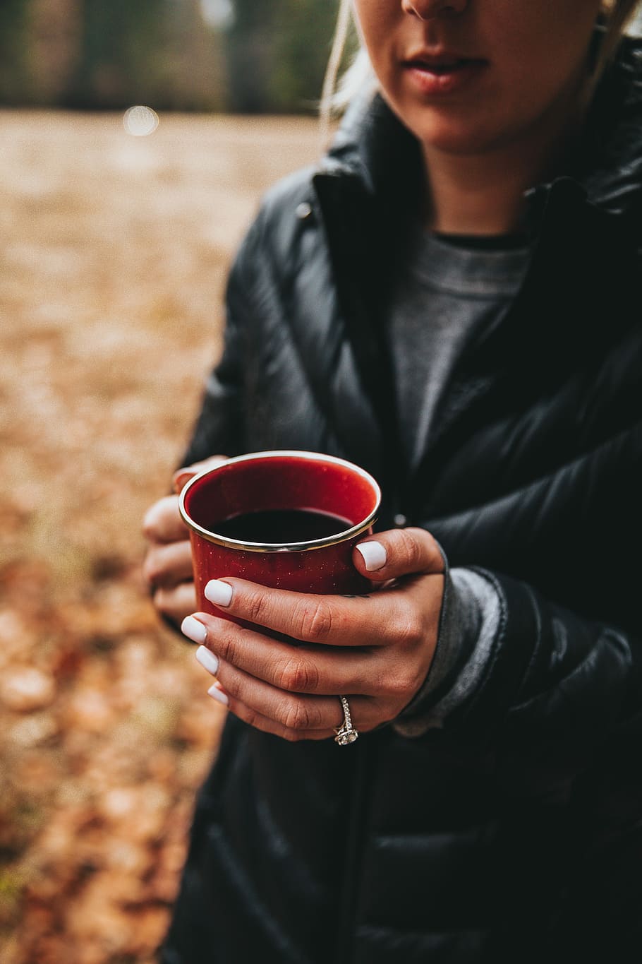 woman holding black liquid-filled red cup selective focus photo, person holding red ceramic mug HD wallpaper