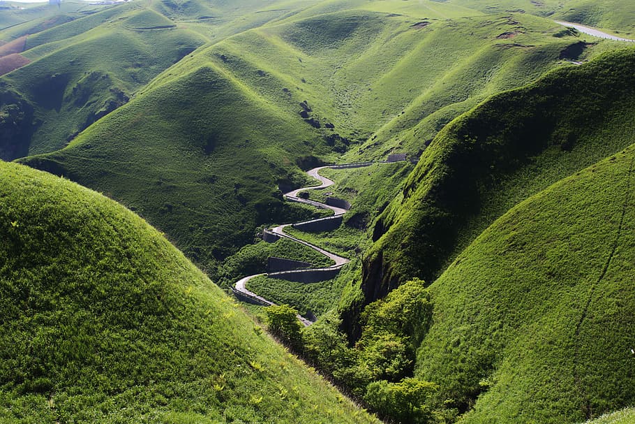 aerial view of mountain hills, aerial photography of green forest mountain with gray road in the middle at daytime HD wallpaper