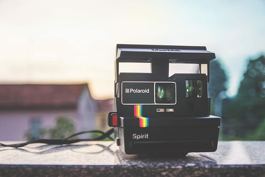 black Polaroid Spirit land camera on gray surfac e, closeup photo of black Polaroid Spirit camera
