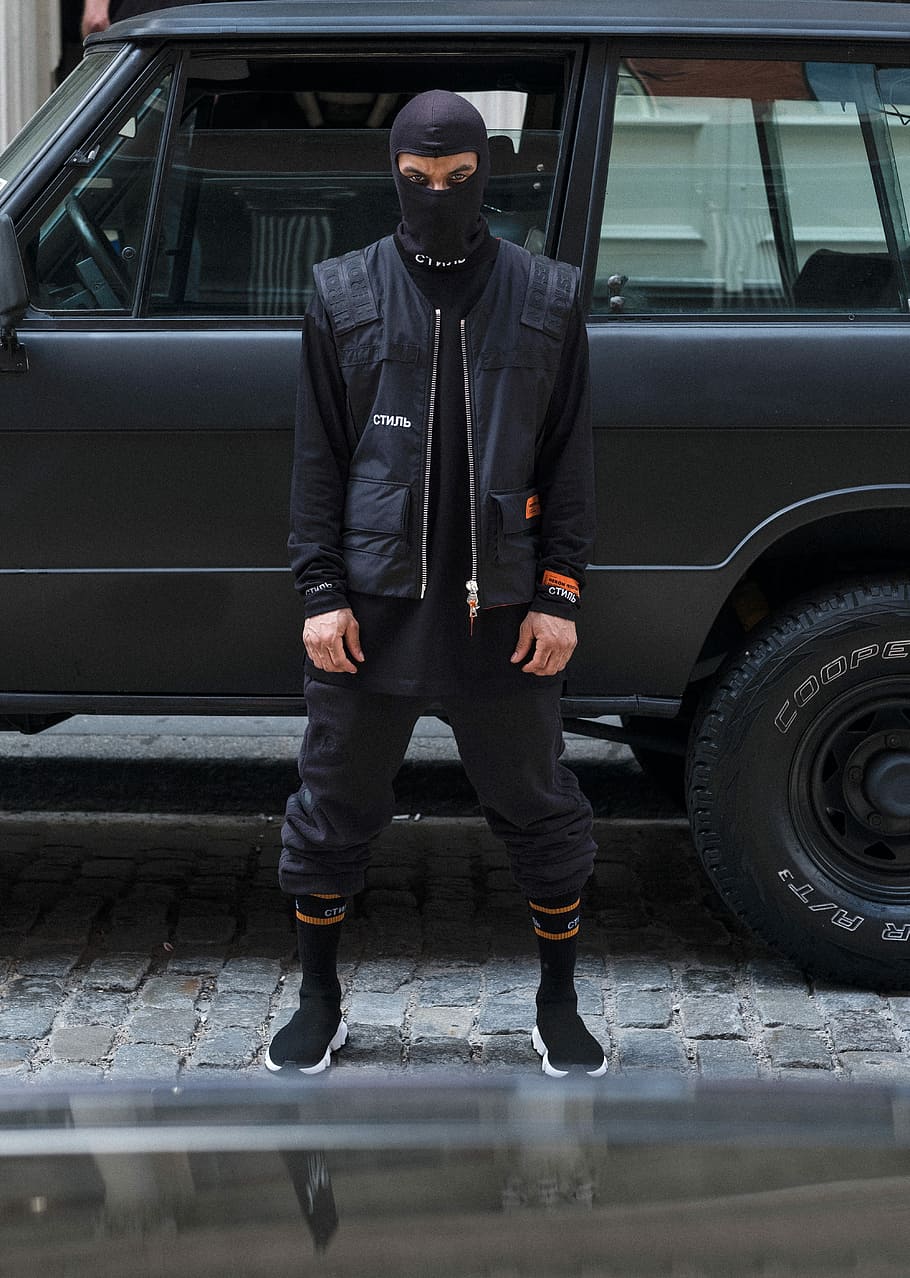 man wearing balaclava standing near car, fashion, style, mask