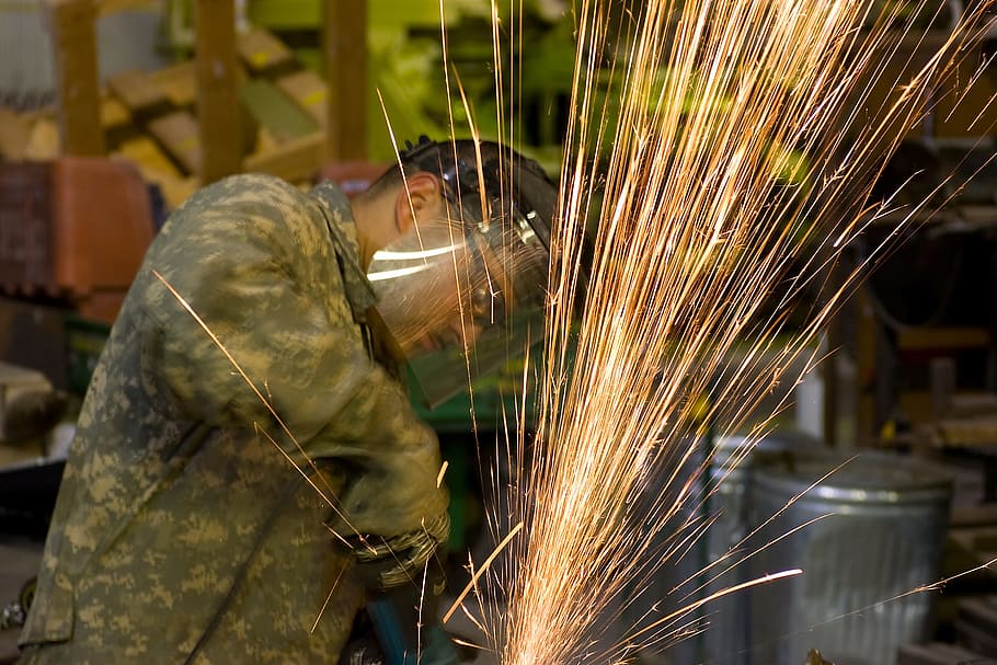 man performing welding wearing protective gears, construction