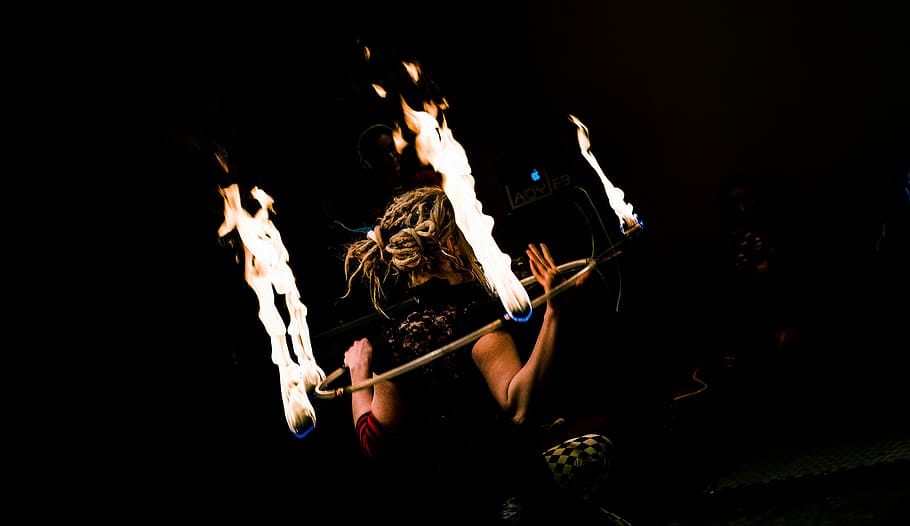 woman holding hula-hoop with fire, person holding gray steel ring with flame HD wallpaper