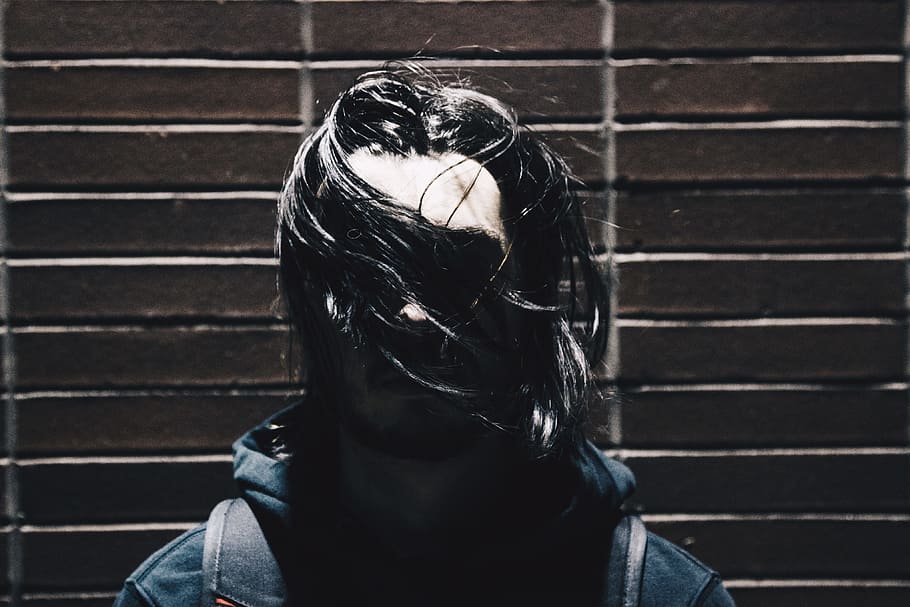 person in black hoodie, woman standing near to wall, shallow focus HD wallpaper