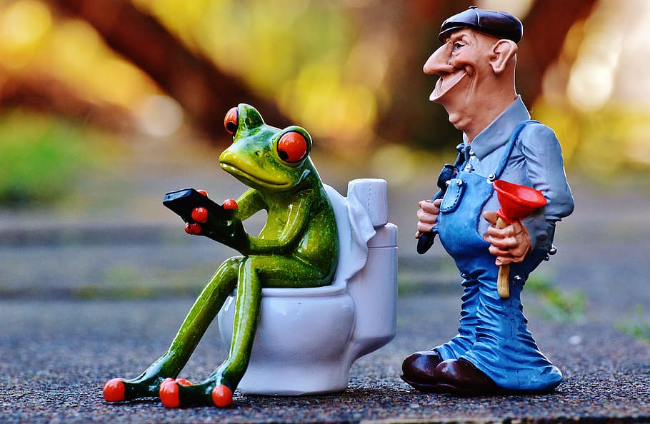 selective focus photography of two Kermit the frog and man figurines