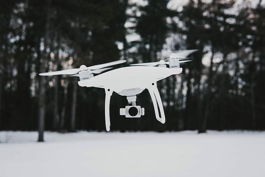 flying quadcopter drone near trees during winter, macro shot of white R/C drone HD wallpaper