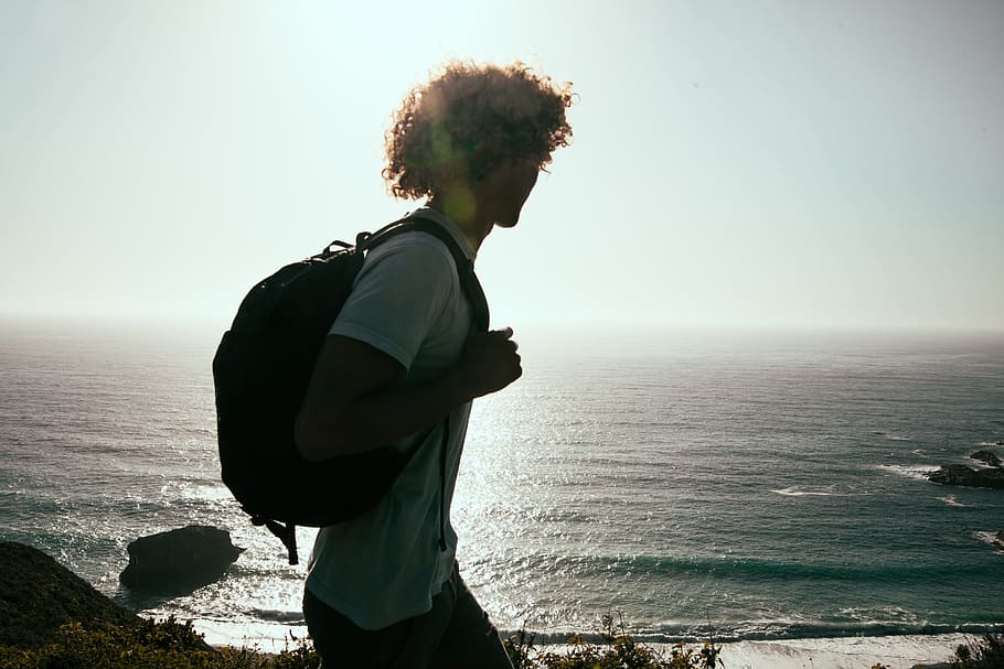 man carrying backpack with sea below, hiking, ocean, beach HD wallpaper