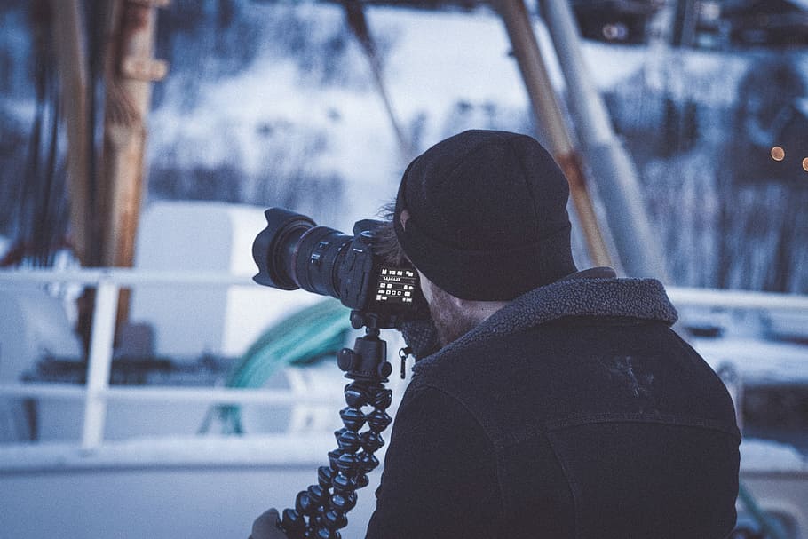 man in black jacket holding DSLR camera, man using black DSLR camera HD wallpaper