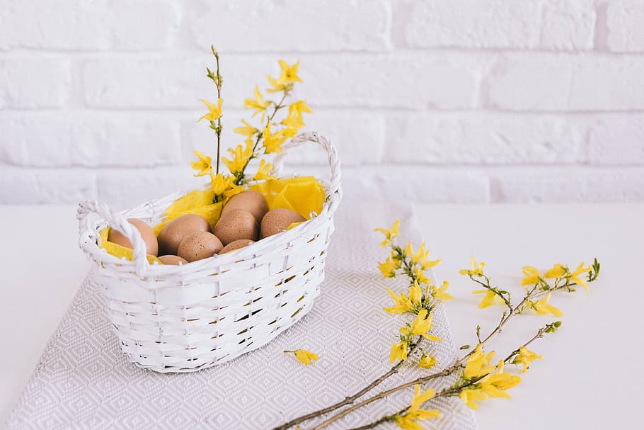 brown eggs in white wicker basket, wall, yellow, flowers, cloth