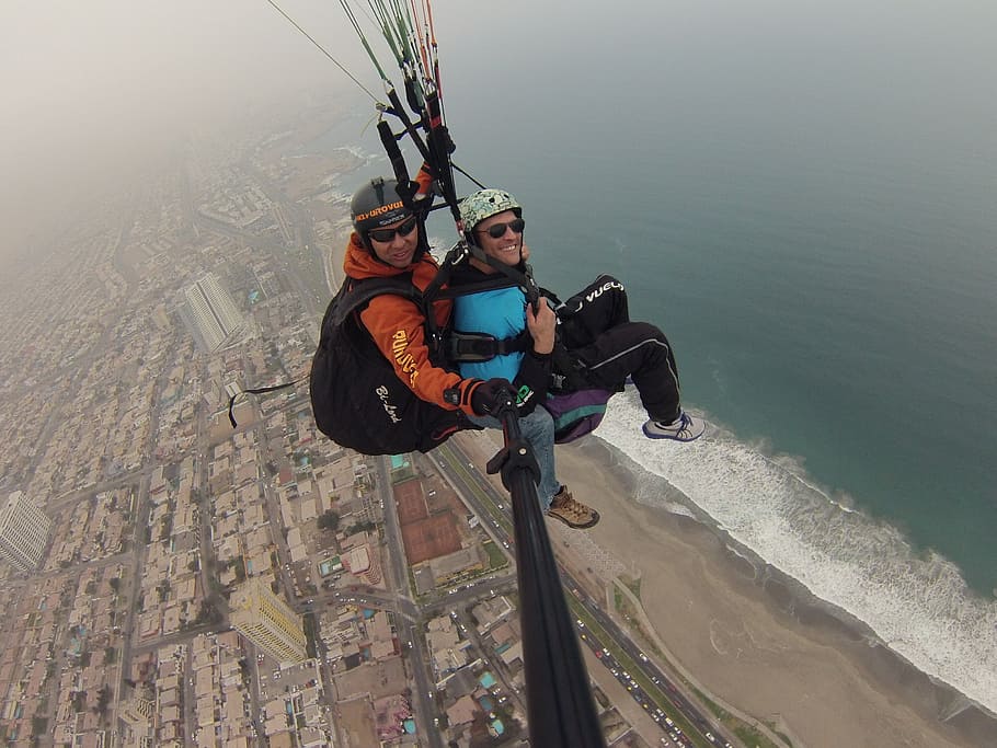 two people taking photo while flying above body of water, paragliding, HD wallpaper