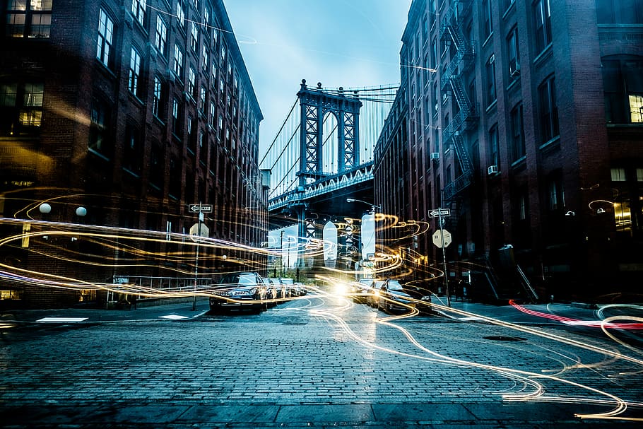 Manhattan Bridge between buildings wallpaper, timelapse photography of buildings near Brooklyn Bridge HD wallpaper