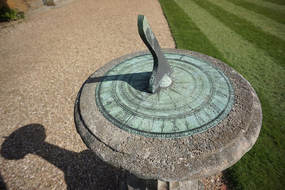 close-up photo of round grey and teal concrete sundial near green lawn HD wallpaper