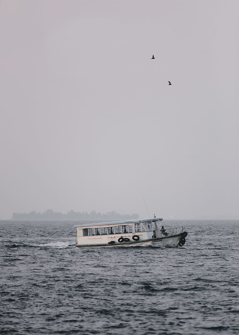 passenger boat during cloudy day, white and teal vessel on body of water under gray sky HD wallpaper