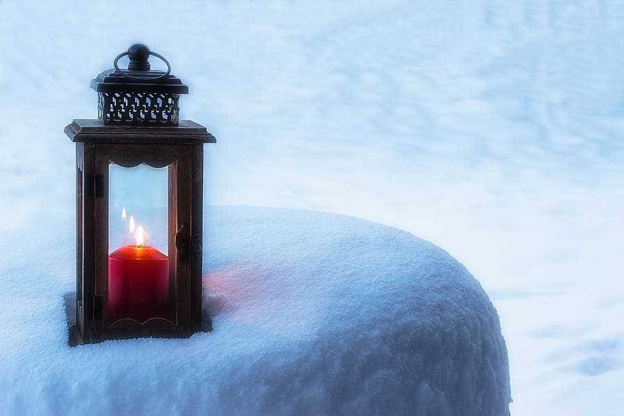 black wooden candle holding with red lit candle inside placed on frosted surface HD wallpaper