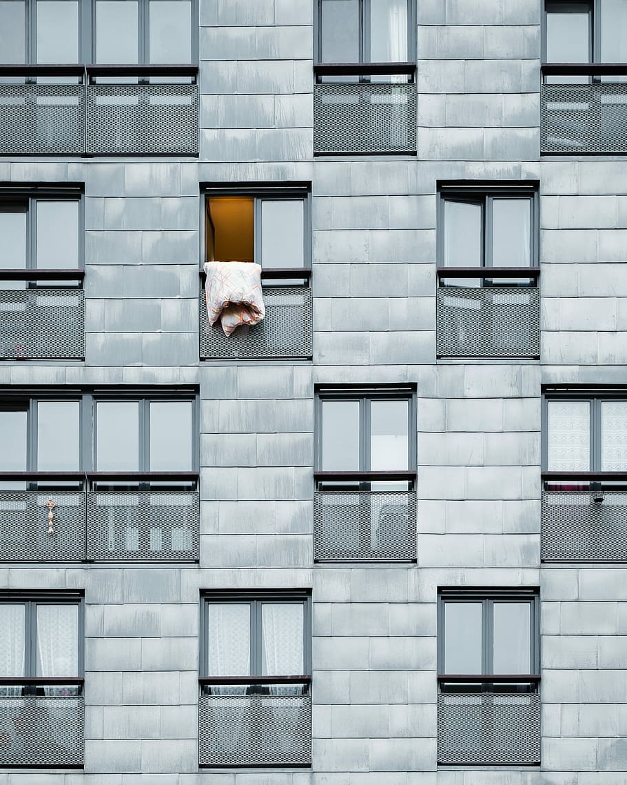 architectural photography of gray condominium building, white bed comforter hanging on an opened apartment window HD wallpaper