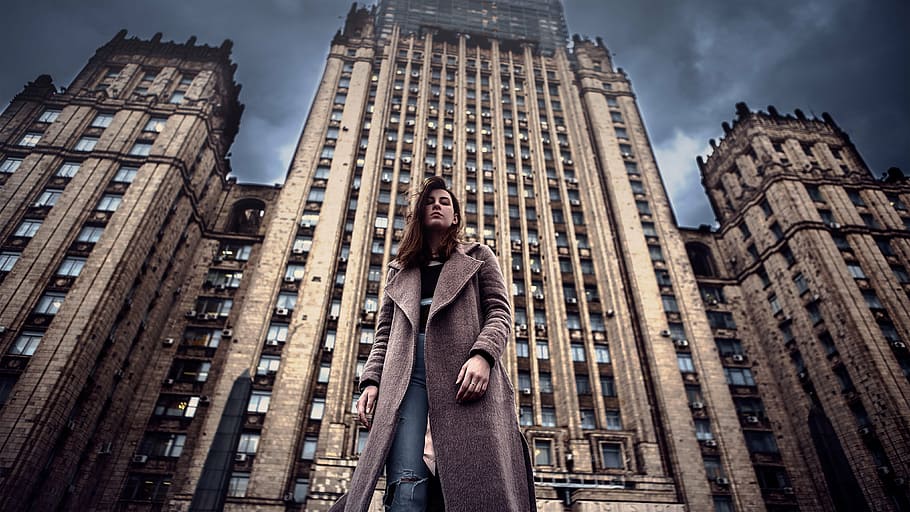 HRD photography of woman standing in front of high-rise building during daytime, HD wallpaper