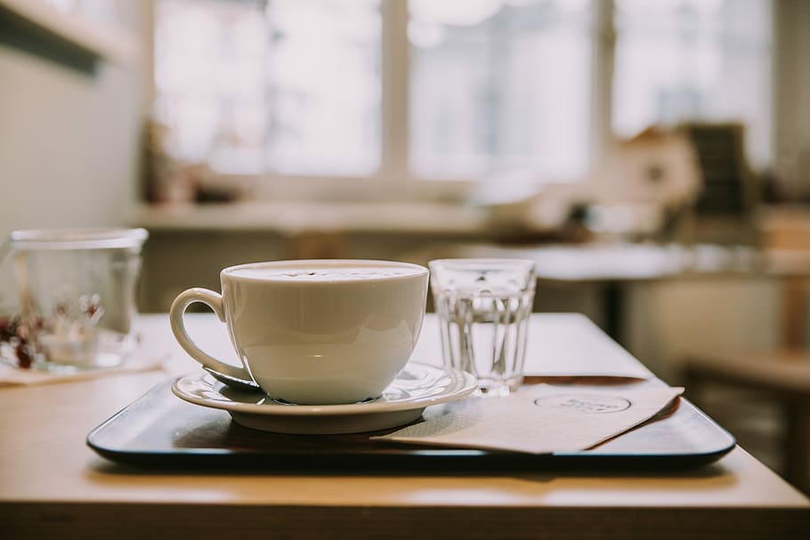 white ceramic tea cup on white ceramic saucer inside room with glass windows, white ceramic teacup near shot glass on tray HD wallpaper