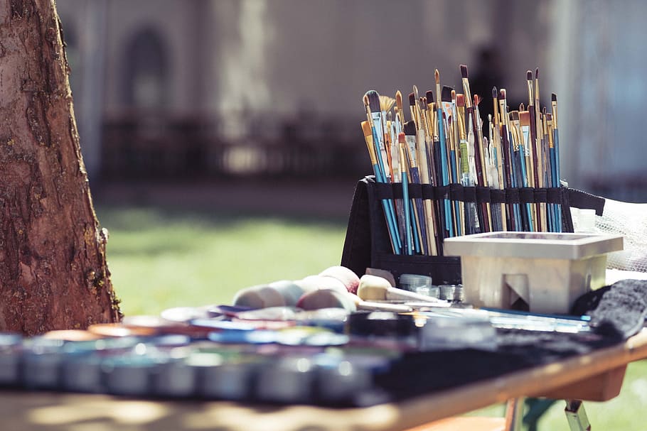 selective focus photography of assorted-shape-and-color paintbrushes on rack, blue, black, and brown wooden paint brush in wooden table HD wallpaper