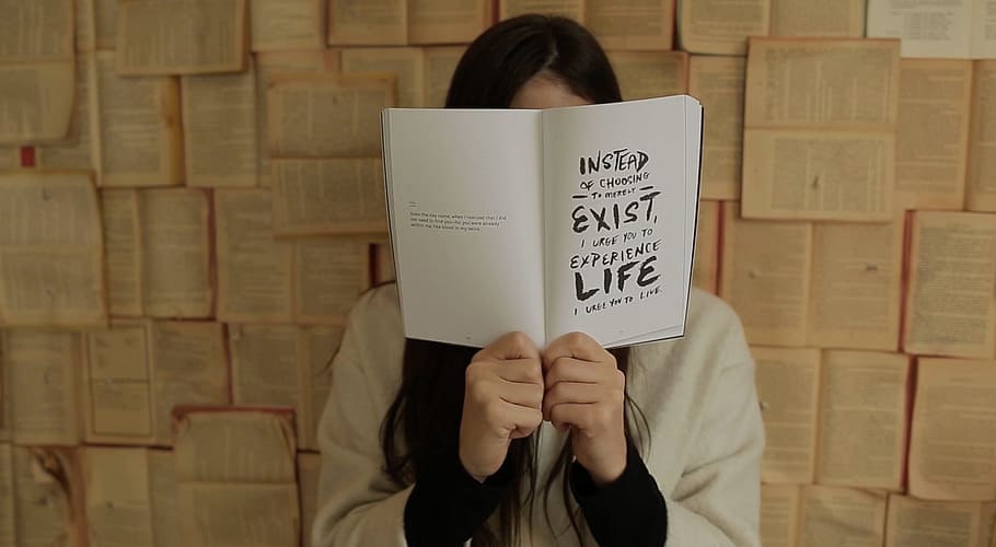 person covering face with book next to book wall, books, read HD wallpaper