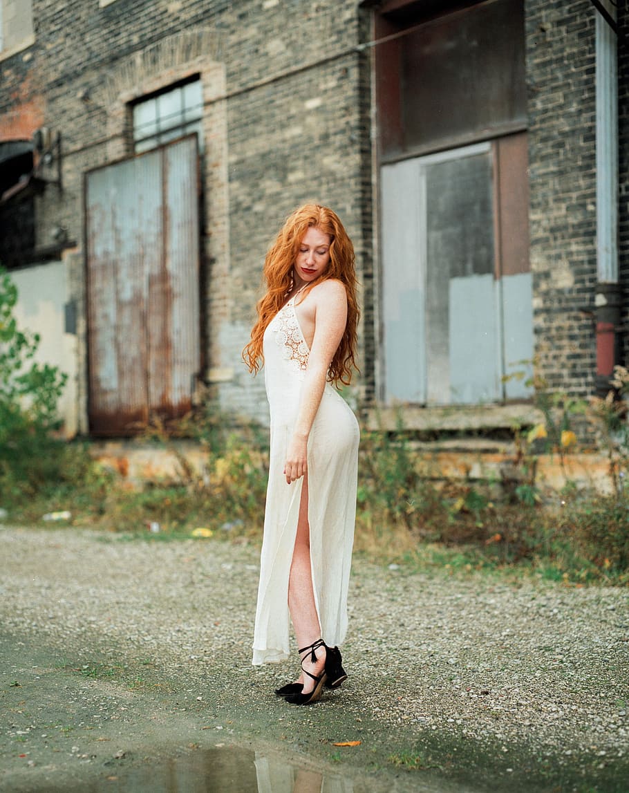 woman standing near brick buildings outdoors, woman wearing white halter dress HD wallpaper