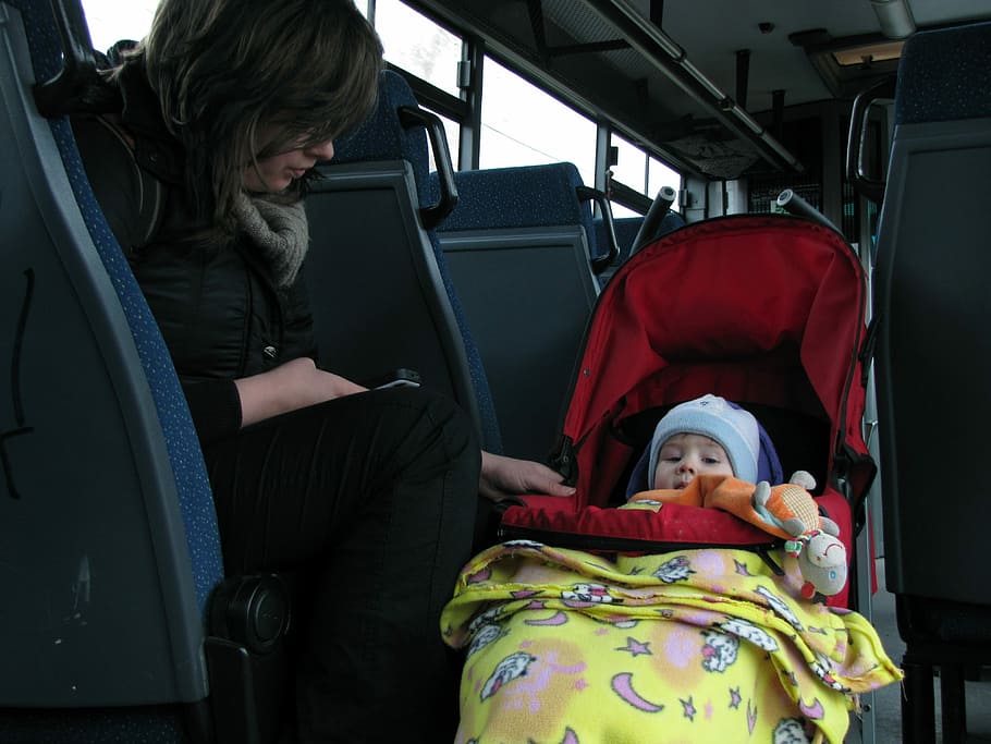 woman sitting on bus chair beside toddler on stroller, Mammy