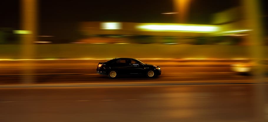 panning photography of black sedan on road near other vehicle HD wallpaper