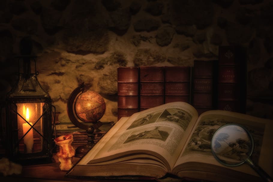 desk globe beside book, old book, lantern, magnifying glass, dark