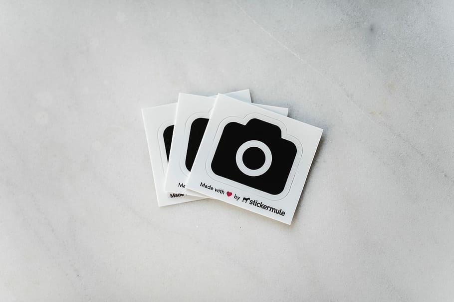 camera stickers, stickermate boxes on white surface, unsplash HD wallpaper