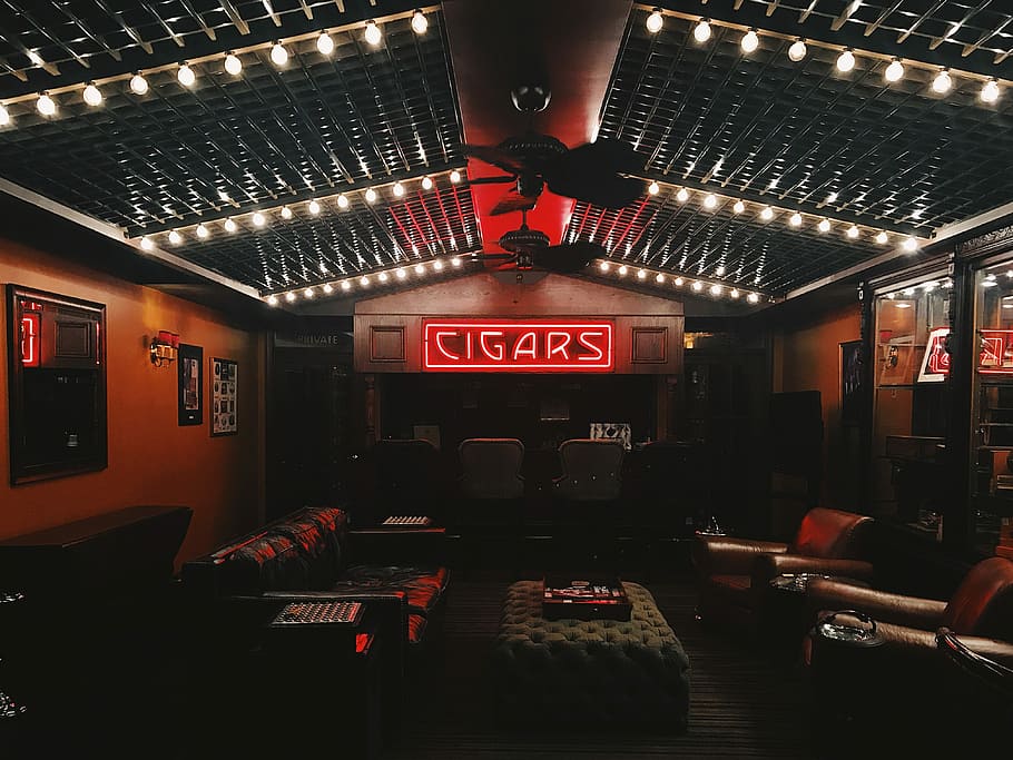 red cigars neon signage in the middle of brown room, Cigars bar interior