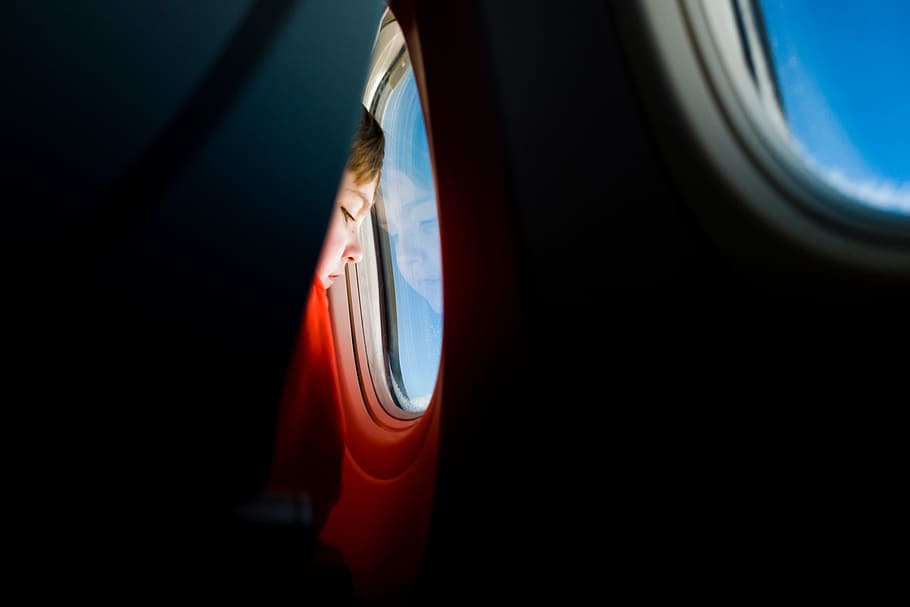 person looking at the window of an airplane, boy inside airliner facing window HD wallpaper