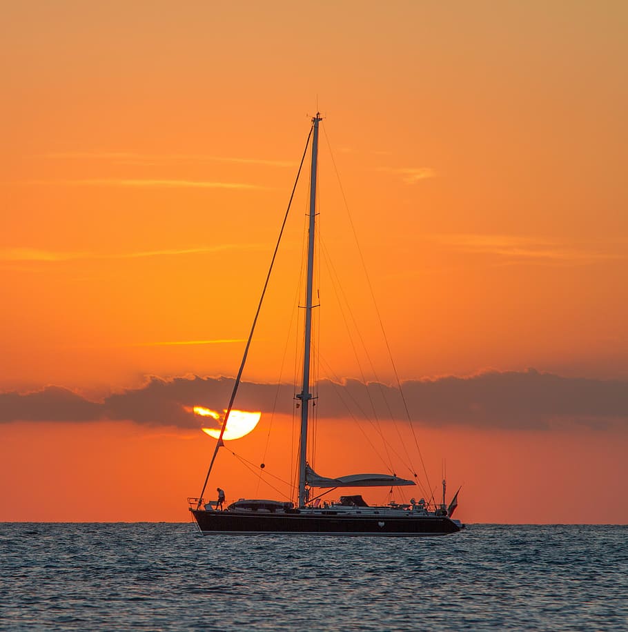 sailing boat on body of water during golden hour, dawn, dusk